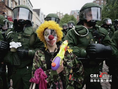 2007年6月2日，德国罗斯托克，八国集团峰会的一名抗议者化妆成小丑站在警察身旁。