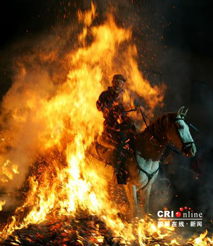 2007年1月16日，西班牙阿维拉，在纪念动物保护神圣安东尼的节日上，一名男子骑马跨过一堆篝火。每年的1月17日是西班牙纪念动物保护神圣安东尼的节日。