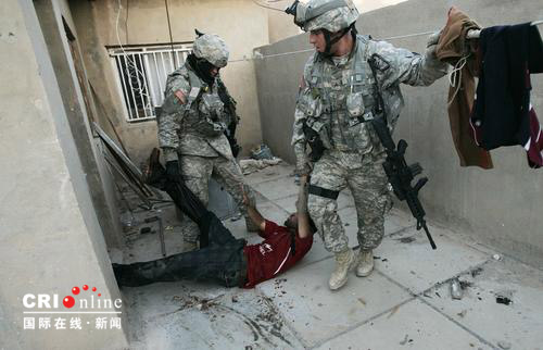 2007年2月8日，伊拉克巴格达，驻伊美军士兵将一名刚刚被打死的伊拉克什叶派民兵组织的嫌疑人拖走。
