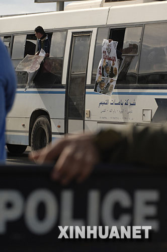 12月3日，一名獲釋的巴勒斯坦人在約旦河西岸城市拉姆安拉附近的貝圖尼亞檢查站手持阿拉法特和阿巴斯的圖像歡呼。以色列監獄部門發言人3日稱，以有關部門當天開始分批釋放429名被關押的巴勒斯坦人。這是以方自今年7月以來第三次釋放巴方囚犯。目前仍有近一萬名巴勒斯坦人被關押在以色列的監獄中。 新華社記者 郭磊　攝 