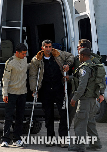 12月3日，在以色列與加沙地帶交界處的以軍埃雷茲檢查站，以色列警察幫助一名剛被釋放的傷殘巴勒斯坦人下車。以色列監獄部門發言人3日稱，以有關部門當天開始分批釋放429名被關押的巴勒斯坦人。 新華社/法新 