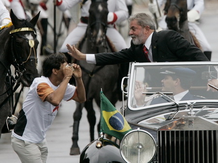 2007年1月1日，一名巴西总统卢拉的支持者在突破安全障碍后给卢拉照相。卢拉乘坐一辆敞篷劳斯莱斯汽车去国会宣誓，开始他的第二个总统任期。