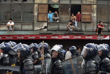 2007年1月12日，菲律宾举行第12届东盟峰会，宿务岛当地民众在阁楼上观看示威后离开的防暴警察。