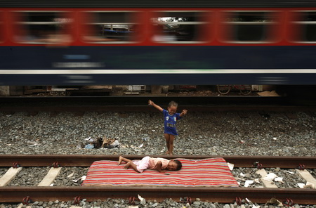 2007年1月30日，印度尼西亚儿童在火车轨道边玩耍，一列火车疾驰而过。