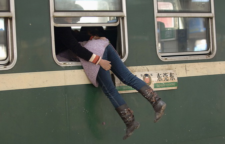 2007年2月26日，中国安徽合肥火车站，一名乘客从火车车窗爬进车厢。
