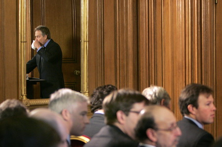 2007年2月27日，伦敦唐宁街每月例行记者招待会，从镜子的反射中可以看到英国首相布莱尔在喝水。