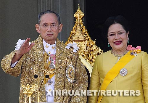 12月5日，泰國國王普密蓬·阿杜德（左）和王后詩麗吉在首都曼谷市中心的大王宮大殿陽臺向人們揮手。