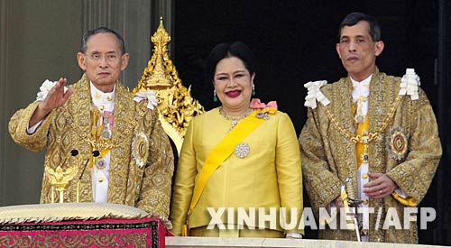12月5日，泰國國王普密蓬·阿杜德（左）與王后詩麗吉（中）、王儲哇集拉隆功在首都曼谷市中心的大王宮大殿陽臺向人們致意。新華社/法新