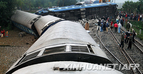 12月10日，人们在印度西里古里附近的火车脱轨事故现场围观。新华社/法新