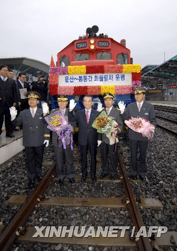 12月11日，在南韓汶山的都羅山車站，列車車組成員與南韓鐵道公社社長李哲（中）在列車出發前合影。新華社/法新