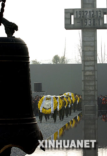 12月13日，武警戰(zhàn)士在敬獻(xiàn)花圈。     當(dāng)日上午10時，凄厲的警報聲響徹南京城上空。中央和國家有關(guān)部門、江蘇省暨南京市各界代表，以及海內(nèi)外和平友好人士近8000人，在侵華日軍南京大屠殺遇難同胞紀(jì)念館集會廣場，隆重舉行悼念侵華日軍南京大屠殺30萬同胞遇難70周年暨侵華日軍南京大屠殺遇難同胞紀(jì)念館擴(kuò)建工程竣工儀式。 新華社記者 孫參 攝 