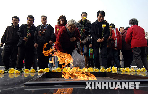 12月13日，南京市民在侵華日軍南京大屠殺遇難同胞紀(jì)念館新落成的祭場獻(xiàn)花。     當(dāng)日上午10時，凄厲的警報聲響徹南京城上空。中央和國家有關(guān)部門、江蘇省暨南京市各界代表，以及海內(nèi)外和平友好人士近8000人，在侵華日軍南京大屠殺遇難同胞紀(jì)念館集會廣場，隆重舉行悼念侵華日軍南京大屠殺30萬同胞遇難70周年暨侵華日軍南京大屠殺遇難同胞紀(jì)念館擴(kuò)建工程竣工儀式。 新華社記者 韓瑜慶 攝 