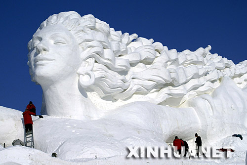 12月18日，工人们在对雪雕艺术博览会主雕塑《浪漫风情》进行局部修整。新华社记者 王建威 摄