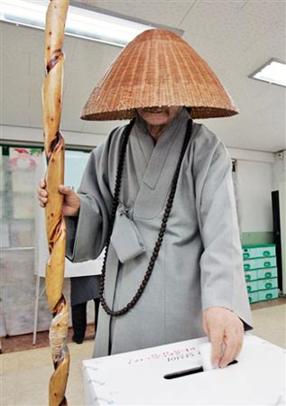 12月19日，一名韩国僧人在首尔一处投票站投票。