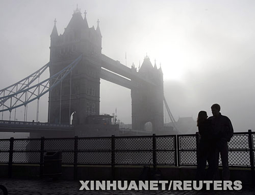 12月23日，一对青年男女站在英国伦敦的塔桥前。伦敦当日大雾弥漫，200多个航班被迫取消。 新华社/路透