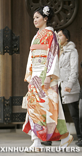 1月14日，在日本首都东京，一名身着和服的女子进入明治神宫参加庆祝活动。