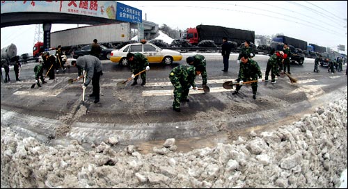 1月30日，工作人员在京珠高速公路湖南段清扫积雪。