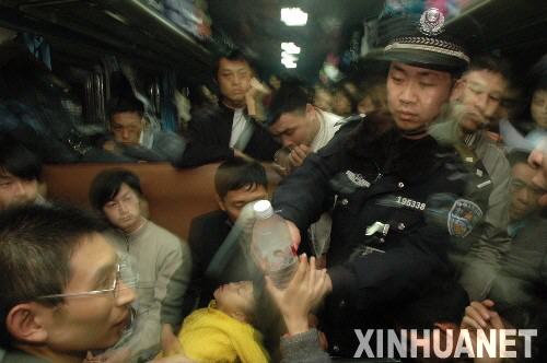 1月30日，广州至宜昌的2286次列车乘警在向旅客发放补给食品。 新华社发（贺瑞明摄）
