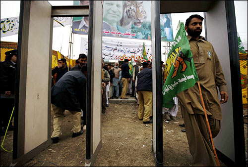 2月14日，在巴基斯坦旁遮普省的阿伯塔巴德，参加穆斯林联盟(谢里夫派)竞选集会的人们从安检门中走过。
