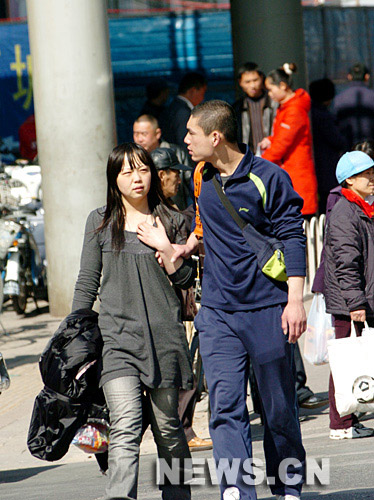 3月4日，著春裝的行人走在北京西單商業(yè)街。