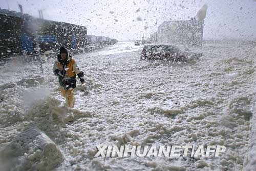 3月10日，在法國西部的聖蓋諾萊，一名海員在風雨中艱難前行。