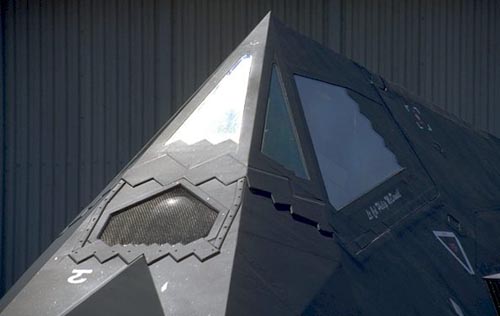 F-117 座舱盖为整体式，镶有 5 块透明平板，其上都有金属镀膜，防止雷达波进入座舱内。座舱盖和各口盖边缘的锯齿可以将雷达波反射至同一方向。机头前方可以看到 FLIR 前视红外转塔。