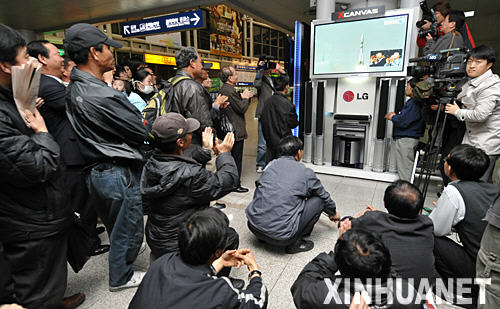 4月8日，在韓國(guó)首都首爾火車站，市民聚集在電視旁觀看“聯(lián)盟”號(hào)飛船發(fā)射升空的轉(zhuǎn)播。