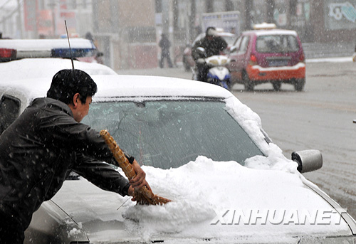 4月21日，寧夏固原市一位市民在清掃汽車上的積雪。受新疆東移較強冷空氣影響，4月20日開始，寧夏迎來大風強降溫天氣過程，位于寧夏南部山區(qū)的固原市迎來了雨雪天氣。 新華社記者 曹健 攝 