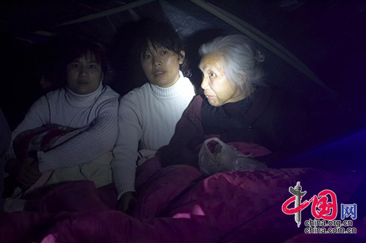 5月13日夜，四川省都江堰市灾区，两个女儿陪伴老人在帐篷里。 李肖军/摄影