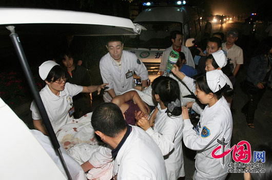5月12日夜，四川都江堰市聚源镇中学，医疗人员把一名重伤者抬上救护车准备送往医院救治。