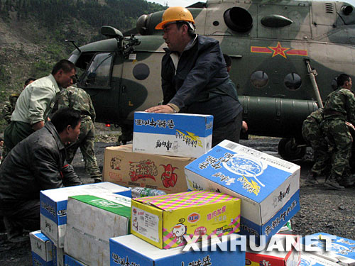 5月14日，救援人员在四川省汶川县映秀镇灾区搬运通过直升机空运的救灾物资