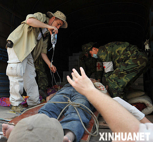 　5月14日，来自美国的留学生郭爱德（左）在北川县协助医生救治伤员。