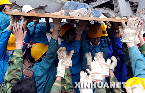 　5月13日，在四川绵竹县汉旺镇一所中学内，救援人员经过十几小时的艰苦努力，终于从废墟中救出一位女学生。新华社记者　李晓果　摄