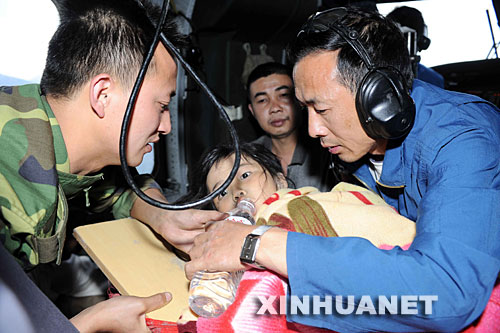 　5月14日，成都军区救援人员骆斌（上）正在救灾直升机上照顾汶川县映秀镇受伤的藏族群众王群英。 新华社记者陈凯摄