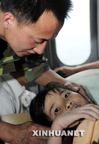 　5月14日，成都军区救援人员正在救灾直升机上照顾汶川县映秀镇受伤的小学生吴璟怡。 　新华社记者陈凯摄