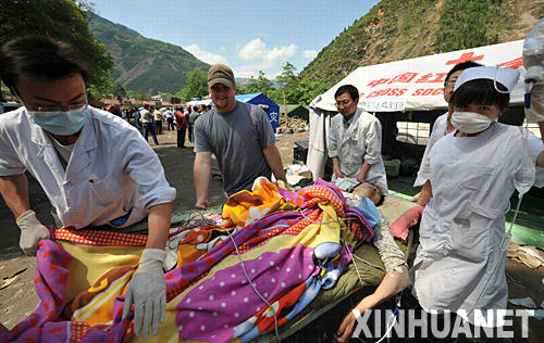 5月14日，来自美国的留学生牧勇士（左二）在北川县与医护人员一起运送伤员