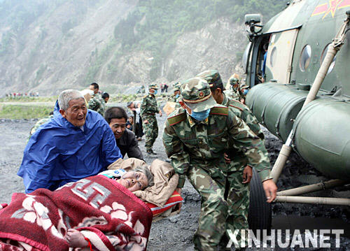 5月14日，救援人员将受伤的老人抬上直升飞机