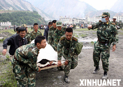 5月14日，武警官兵在汶川县映秀镇将受伤的群众抬上直升飞机