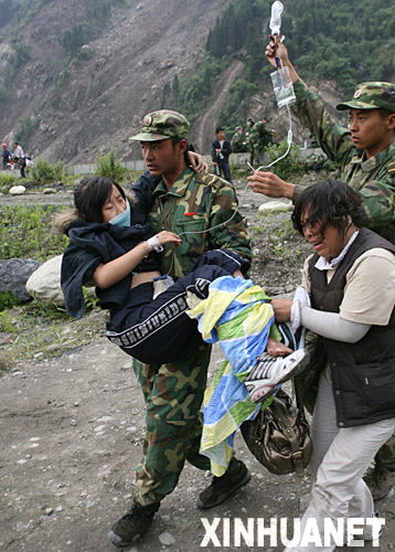 5月14日，救援人员在汶川县映秀镇抢救一名腿被砸伤的中学生，旁边是她焦急的母亲