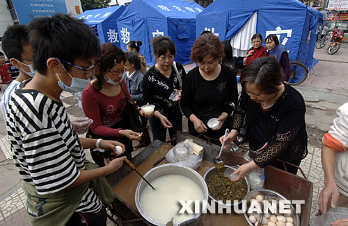 5月15日上午，绵阳市下岗职工程兰（右一）等人自发出钱、出力为灾民做饭送饭