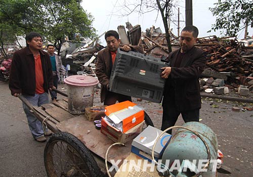 5月14日，四川绵竹市遵道镇居民在废墟中抢救财产