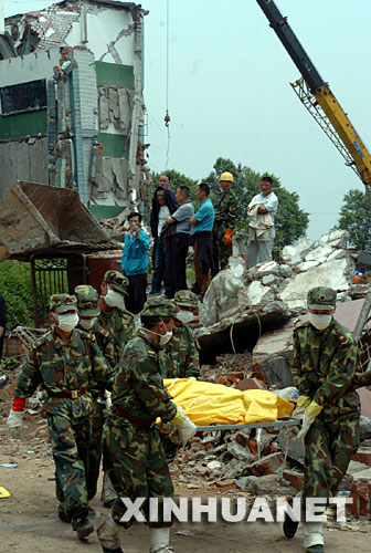 5月15日，解放军战士从绵竹市汉旺镇东汽中学抢挖出被掩埋的学生