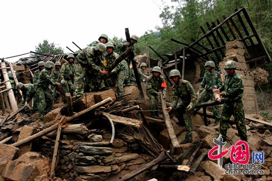 5月15日下午，甘肃陇南碧口镇，武警士兵们正在清理震后房屋的废墟。 田蹊/摄影