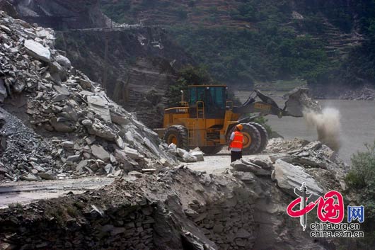 5月15日下午，甘肃陇南碧口镇，被山体塌方堵住的路正在恢复中。 田蹊/摄影