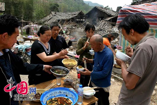 5月15日下午，甘肃陇南碧口镇，邻居们一起吃饭。 田蹊/摄影