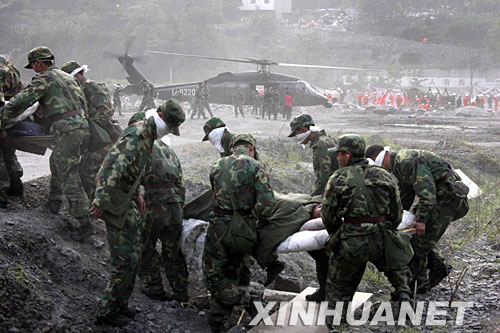5月15日，救援人员向直升机上抢运伤员