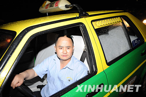 一名从成都自发赶来参加救灾的出租车司机在都江堰市街头等待接送伤员