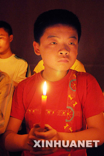 5月16日晚，湖北省宜昌市特殊教育学校的盲童手捧点燃的蜡烛，为在地震中遇难的小朋友哀悼，为幸存者祈福。 新华社发(刘保平 摄) 