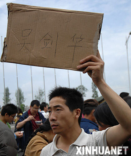 5月14日，一位市民在四川绵阳市九洲体育馆前举着牌子找人