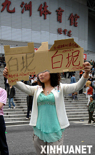 5月14日，一位市民在四川绵阳市九洲体育馆前举着牌子找人。